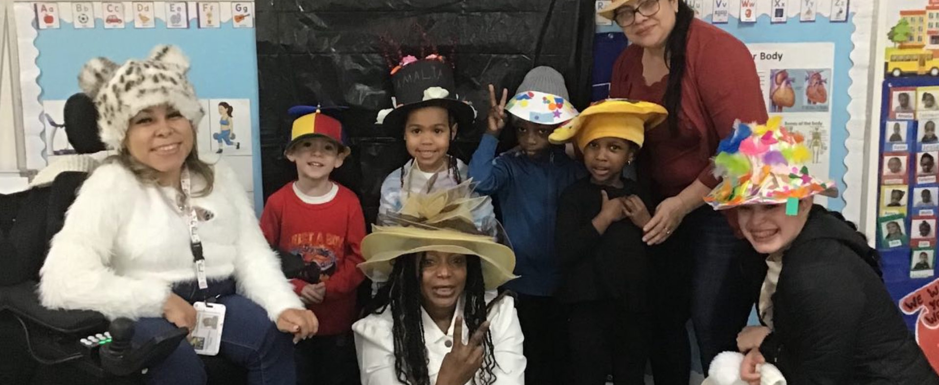 female kid putting can in the box with female teacher