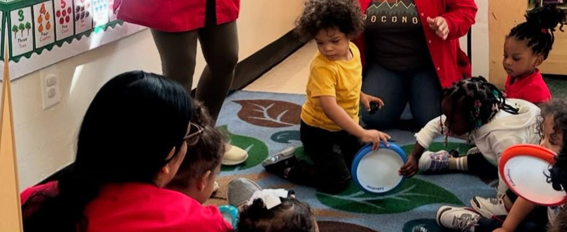 male teacher reading book story to kids