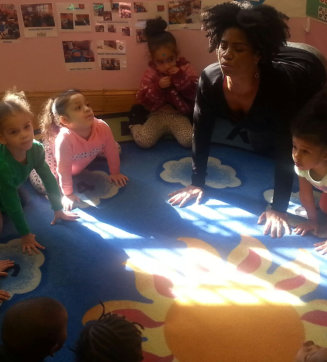 female teacher with little kids doing yoga