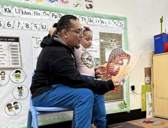female teacher smiling while teaching male kid