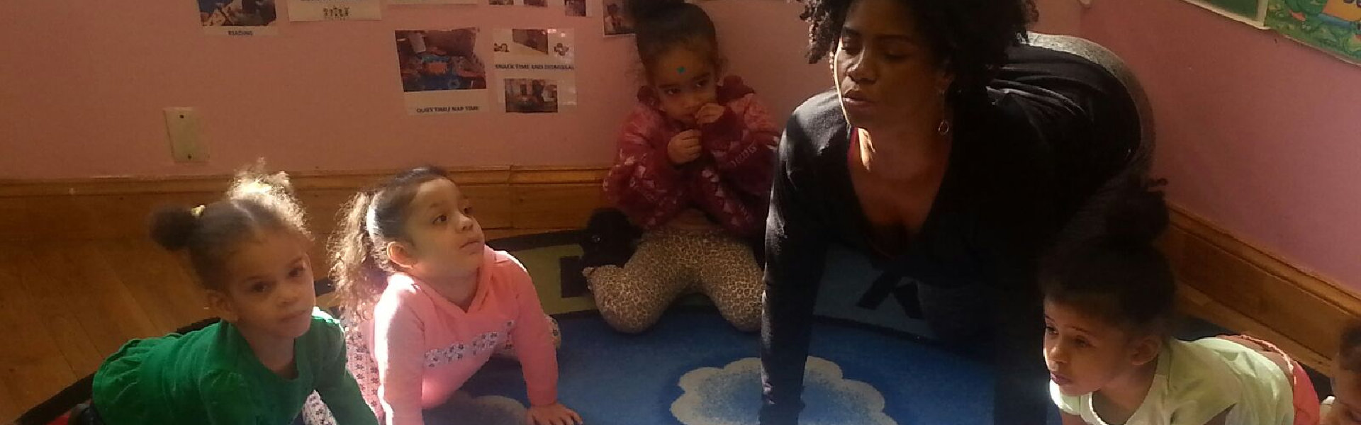 female teacher with little kids doing yoga