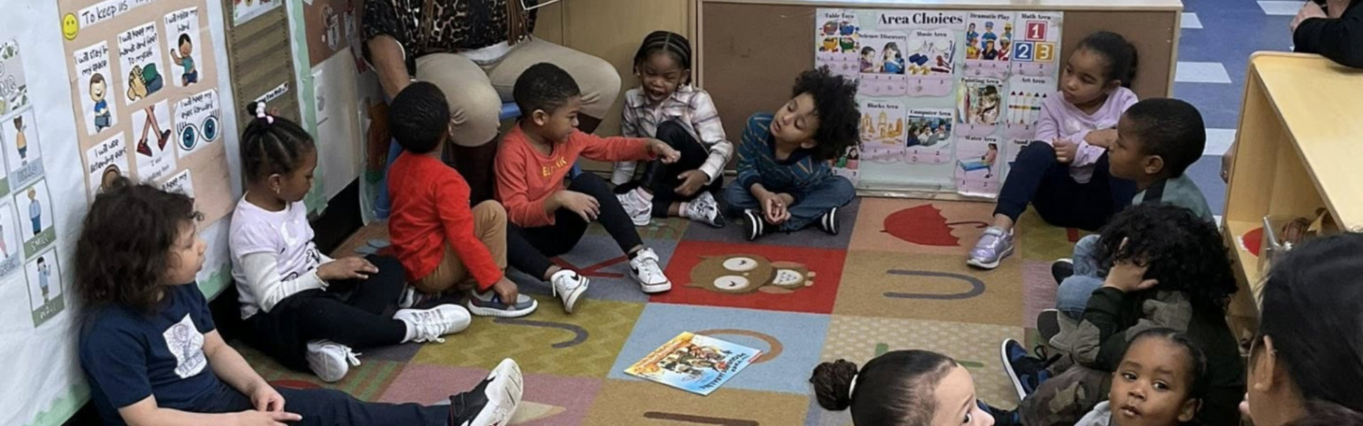 kids sitting on the floor while teacher discussing