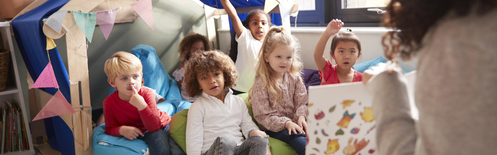 group of children listening to a discussion with female teacher