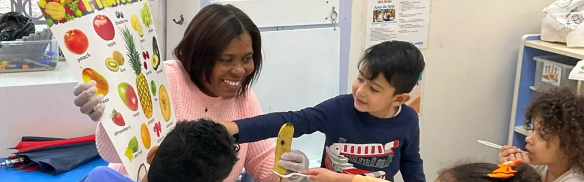 female teacher teaching name of fruits