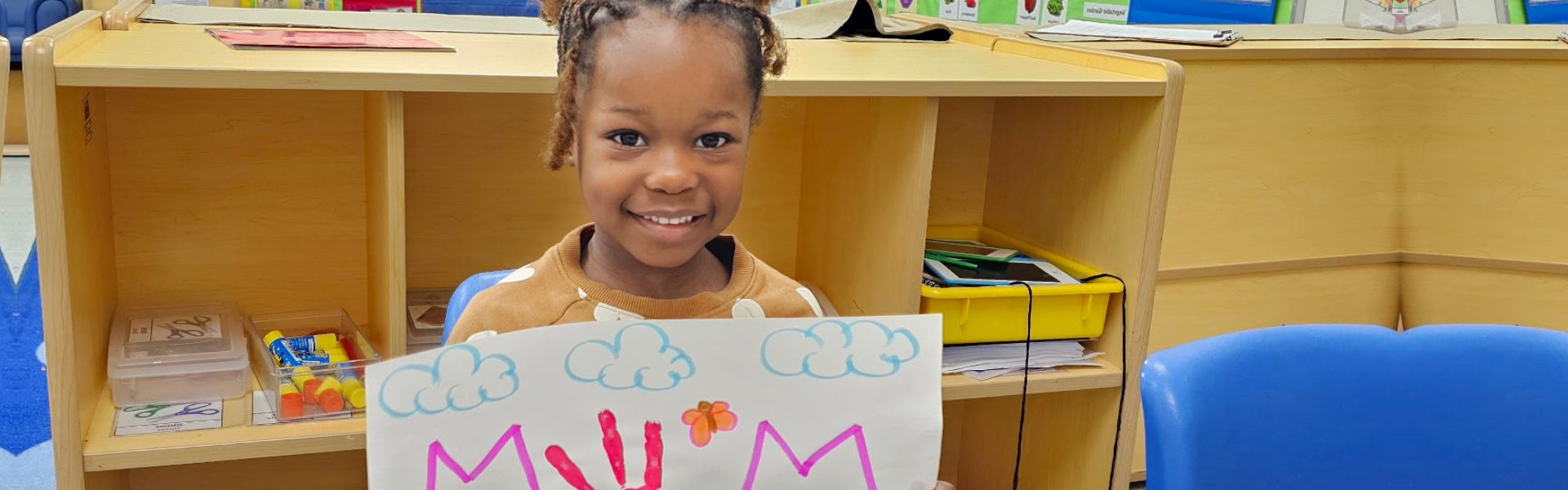 little girl smiling with her art drawing