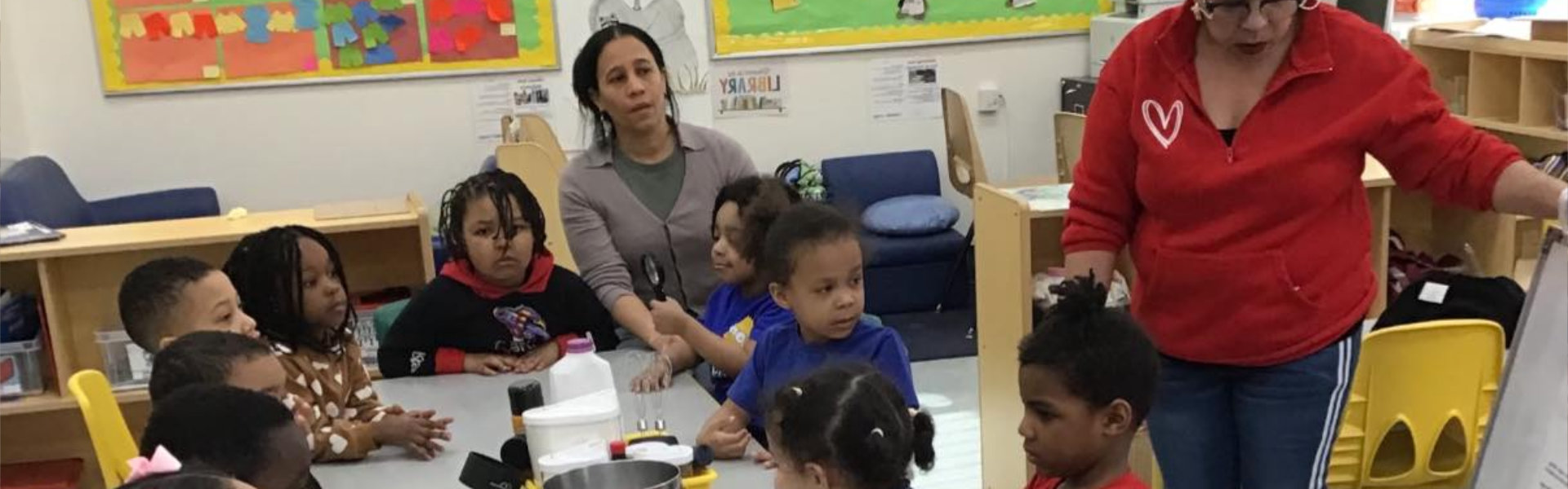 group of children sitting with teachers