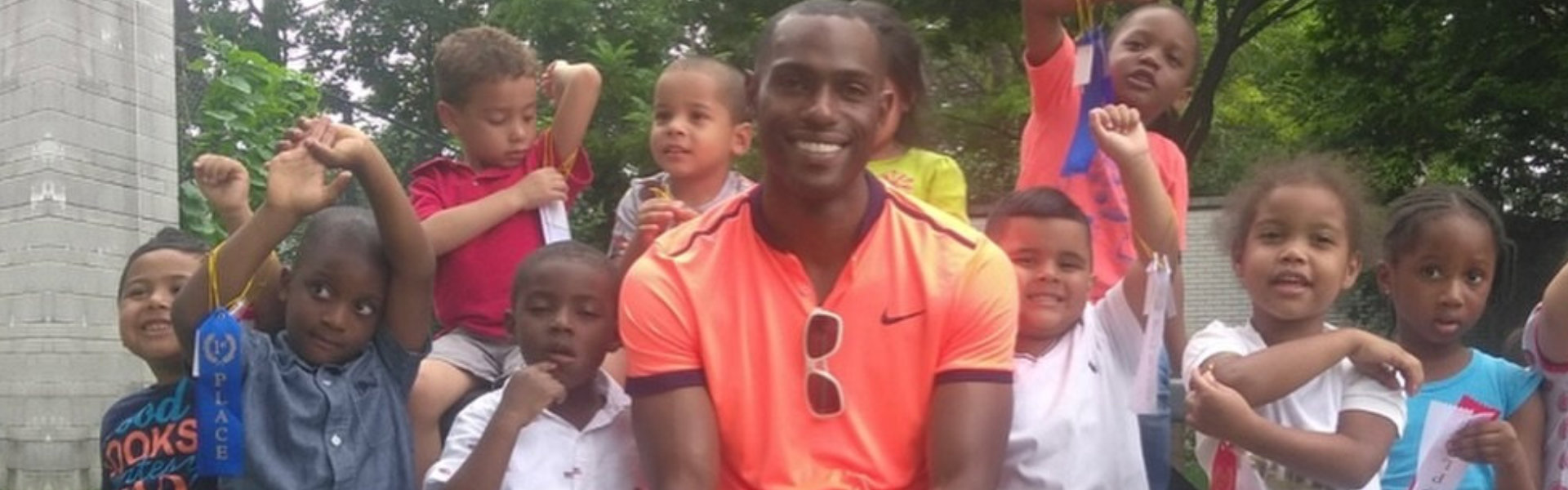 man smiling with group of kids